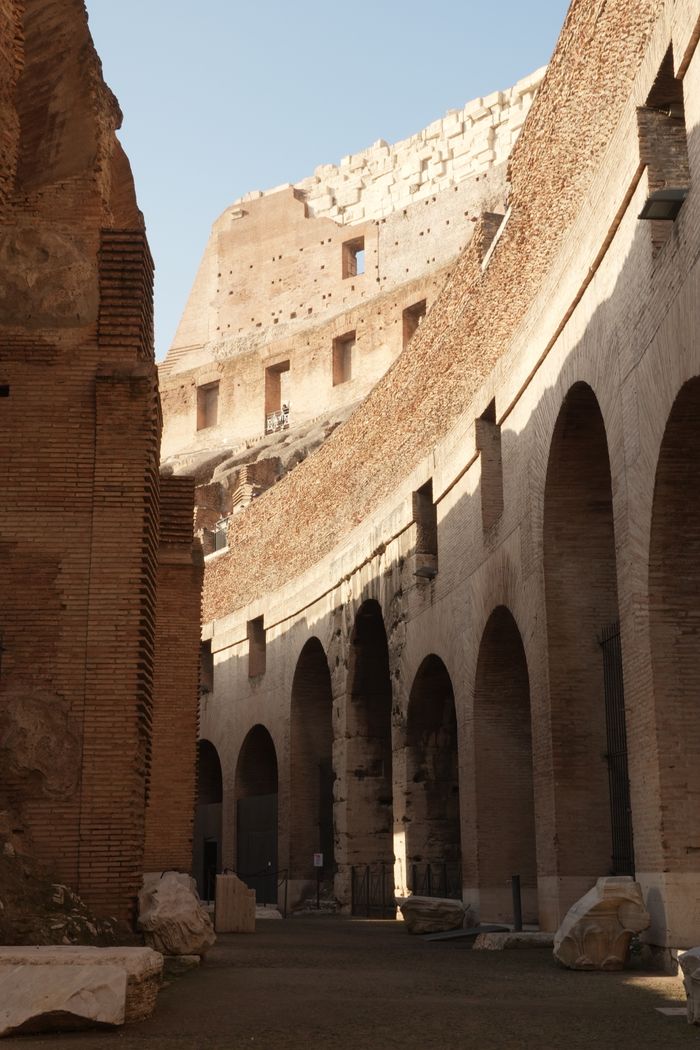 Interior view of the Colosseum's ancient arches and walls in Rome, Italy.